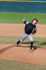 Little league baseball pitcher in wind up throwing the ball.