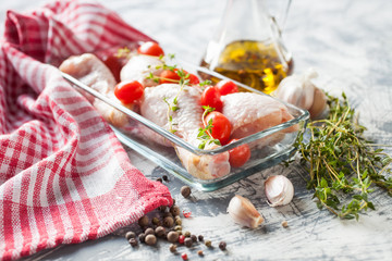 chicken legs and tomatoes in ware for roasting, selective focus