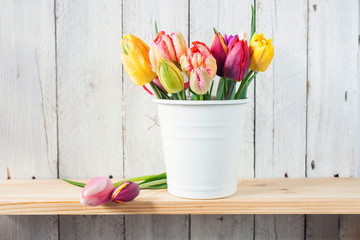 bouquet of tulips in a bucket on the shelf, selective focus