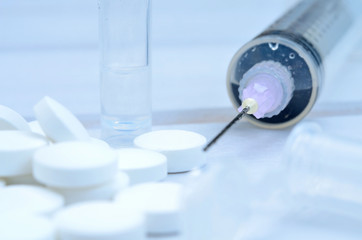 pills and syringe on table