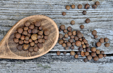 allspice with wooden spoon on table