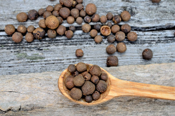 allspice in spoon on table