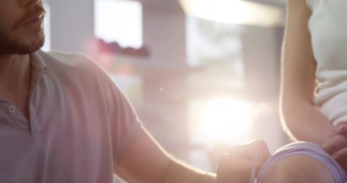 Physiotherapist measuring female patient knee with goniometer