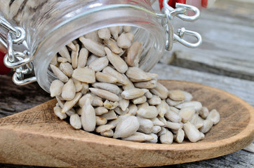sunflowers seed in jar flow in spoon on table