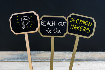 Concept message REACH OUT to the DECISION MAKERS and light bulb as symbol for idea