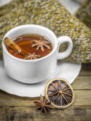 Cup of hot tea with cinnamon sticks and delicious dried lemon