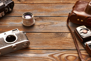 Vintage cameras and lenses on wooden background