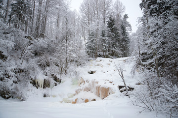 Fototapeta na wymiar Frozen waterfall Yukankoski overcast January day. Winter Karelia
