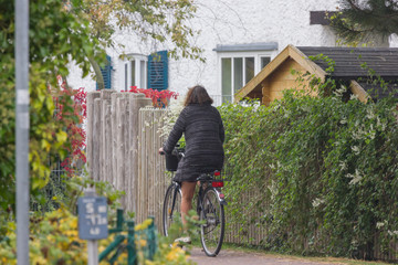 Frau fährt im Herbst auf dem Fahrrad durch die Stadt 