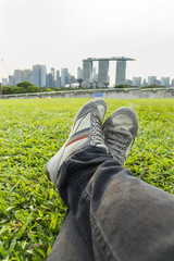 scene of relax man sit on the green grass in the singapore city - can use to display or montage on product