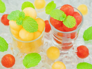 Small sphere shape of cantaloupe and watermelon in a glass with mint and ice decoration