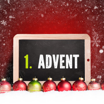 Weihnachtskugeln im Schnee und Kreidetafel mit Text "1. Advent"
