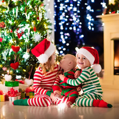 Fototapeta na wymiar Kids in pajamas under Christmas tree