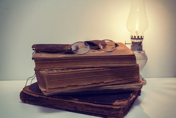 Vintage books with old eyeglasses and case, kerosene lantern
