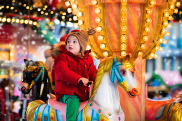 Fototapeta na wymiar Child riding carousel on Christmas market