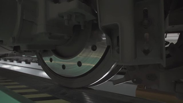 Wheels on chassis of train wagons at workshop in factory. Modern transportaion concept.