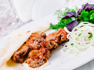 Grilled beef with pita bread and onion on white plate