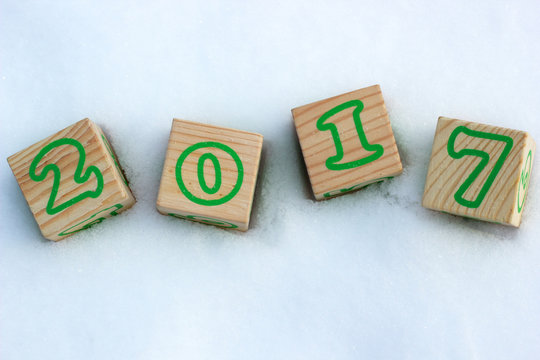 Merry Christmas and Happy New Year 2017. Wooden cubes with the numbers 2017 in the snow.