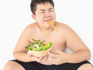 A fat boy hate to eat vegetable salad