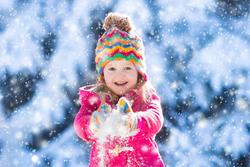 Obraz na płótnie Canvas Child having fun in snowy winter park