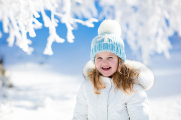 Child having fun in snowy winter park