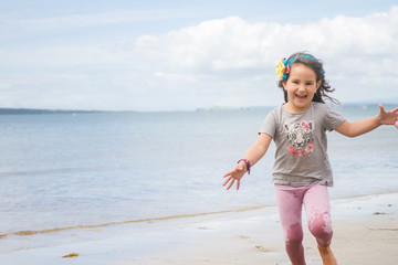 Happy little kid girl having fun with running through water in o