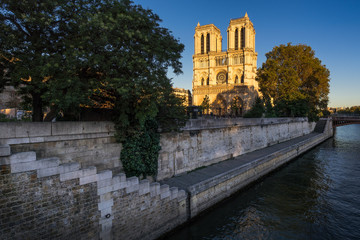 Fototapeta na wymiar Notre Dame de Paris cathedral at sunset with the Seine River on Ile de La Cite. Summer evening in the 4th Arrondissement, Paris, France