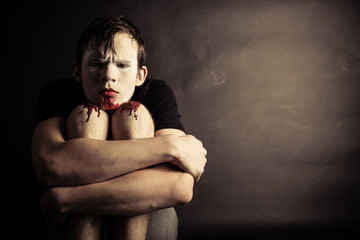 Boy stares seriously at camera while seated