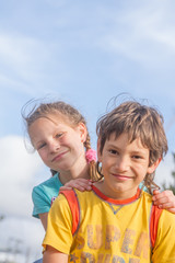 two happy kids - boy and girl - outdoor portrait