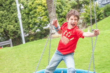 Happy young boy on the playground at the day time