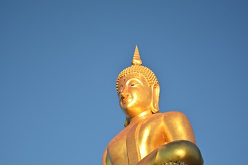 Fototapeta premium Buddha statue/ Buddha statue on a pedestal blue sky background Wait for believers to worship
