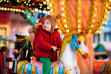 Fototapeta na wymiar Child riding carousel on Christmas market