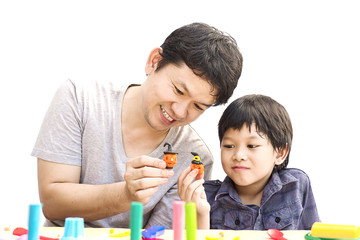 Obraz premium Father is playing Halloween clay with his son over white background