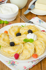 Homemade dumplings (vareniki) with cottage cheese and berries. Traditional Ukrainian and Russian dish.
