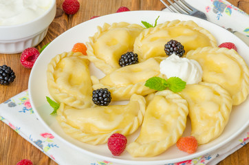 Homemade dumplings (vareniki) with cottage cheese and berries. Traditional Ukrainian and Russian dish.