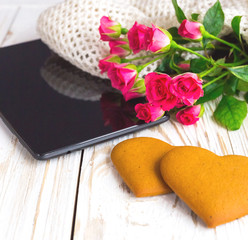 Warm knitted plaid, bouquet of roses and tablet