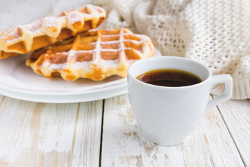Warm knitted plaid, cup of coffee and Belgium waffles