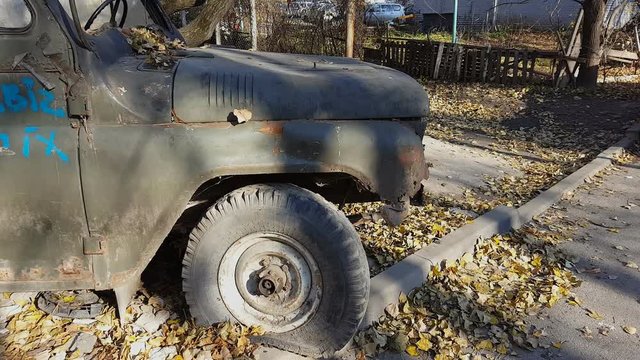 Rusty old abandoned car. Retro old Soviet Russian jeep UAZ. Steadicam shot.