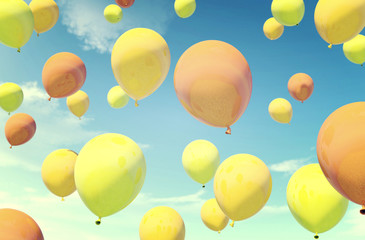 Colorful orange and yellow balloons floating in summer holidays in vintage color filter, concept of summer, holidays, and joyful