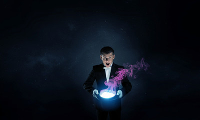 Fototapeta na wymiar Businessman demonstrating magic . Mixed media