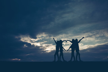 Silhouettes four female friends were on hand at sunset.