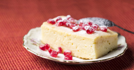 Cake with pomegranate seeds on red background