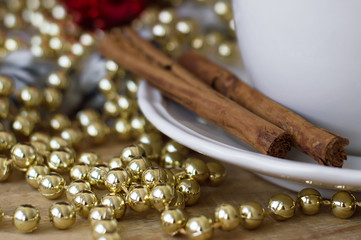 Two cinnamon sticks on wooden table with christmas decoration