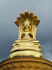 closeup shot of Sirisattarat Buddha, a posture of bhudda statue covered with seven nagas or serpent deities in Indian mythology, made of bronze