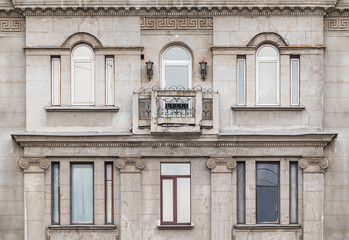 Several windows in a row and balcony on facade of the urban apartment building front view, St. Petersburg, Russia.