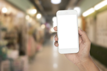Hand holding smartphone with blurred image of shopping mall