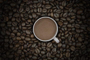 hot coffee in cup on coffee beans background