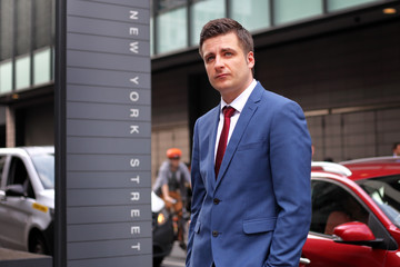 Handsome, self confident, good looking, experienced, successful businessman looking 
into the bright financial future standing on New York Street in Manchester City Centre, England. 