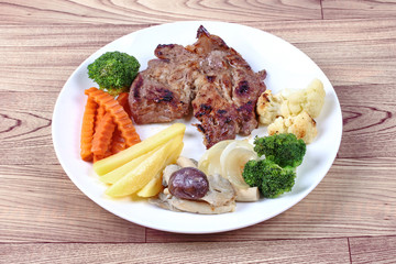 Home made ,Pork steak and mixed vegetables served.