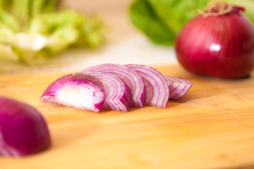 cropped onion with other vegetables on a cutting board